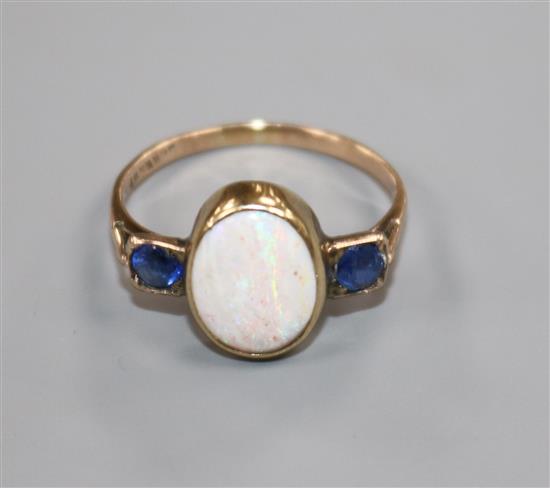 A 14ct gold, three stone white opal and sapphire dress ring, size M.